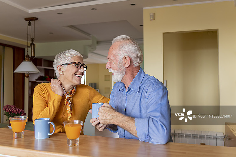 一对老夫妇正在享受早晨的热咖啡和橙汁。图片素材