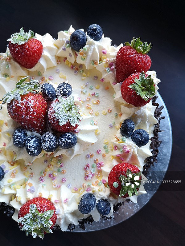 用新鲜浆果装饰的白色奶油蛋糕图片素材
