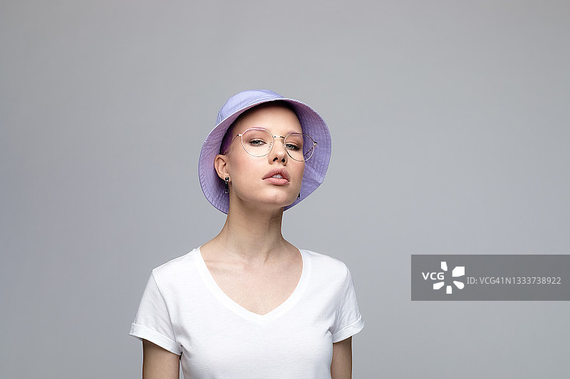 自信的年轻女人戴着淡紫色水桶帽图片素材