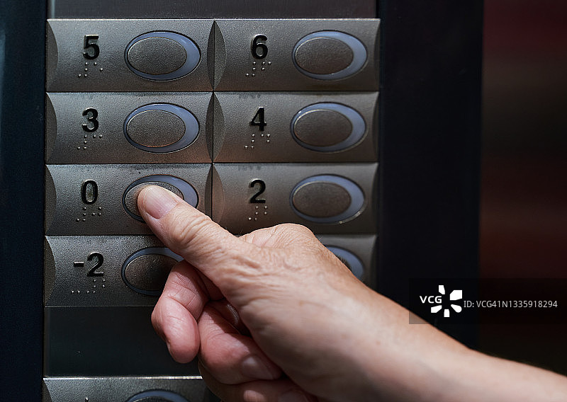 白人拇指在电梯上按按钮的正面照片图片素材