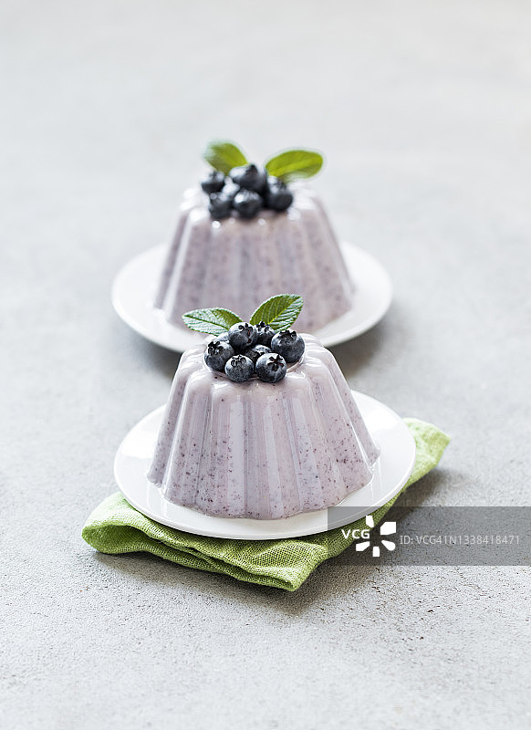 奶油浆果甜点，浅灰色背景的蓝莓意式奶冻图片素材