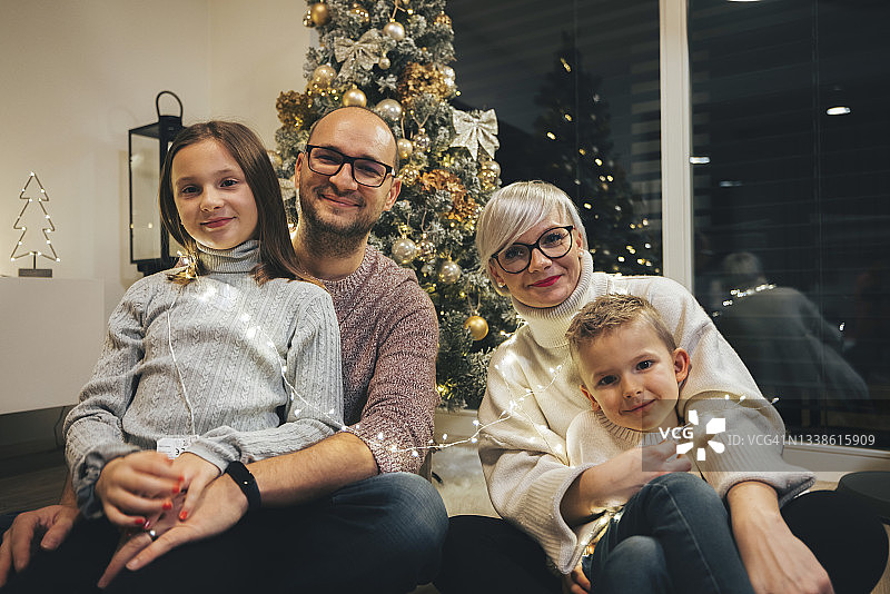 白种人一家四口坐在圣诞树前图片素材