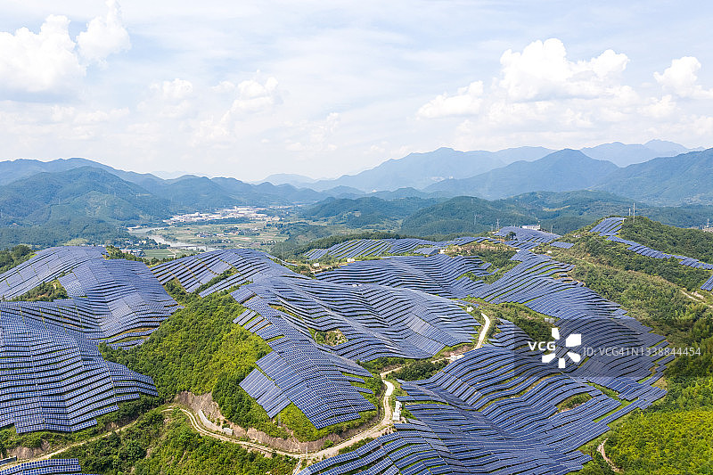 在阳光明媚的日子，从山顶俯瞰壮丽的太阳能发电厂图片素材