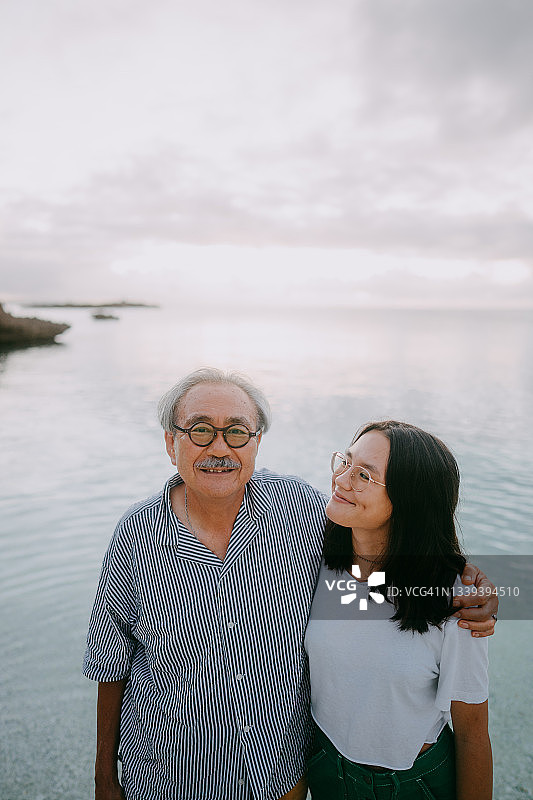 爷爷和孙女在黄昏的海滩上玩得很开心图片素材