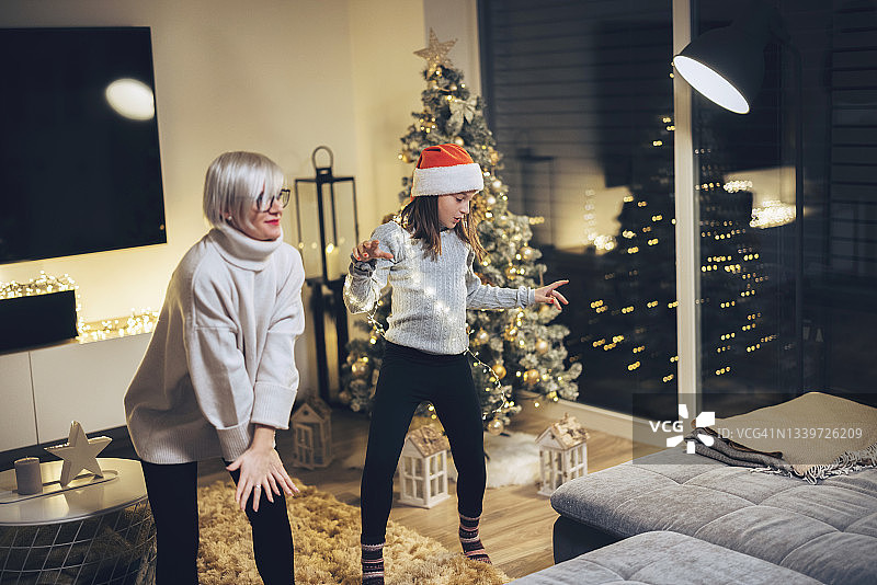 一个小女孩在圣诞节和她的妈妈跳舞图片素材