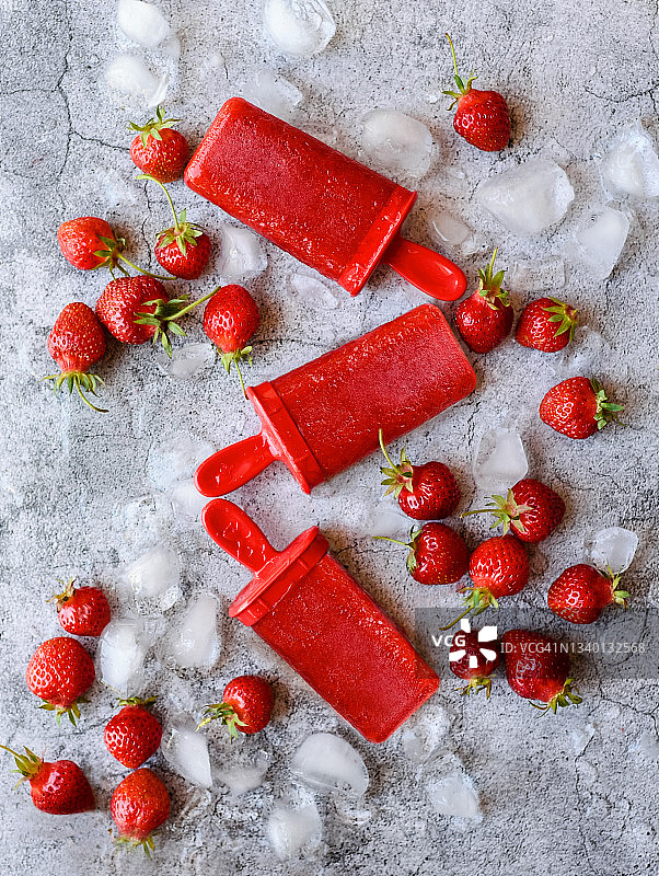 头顶上是草莓冰棒，上面有浆果和混凝土上的冰。图片素材