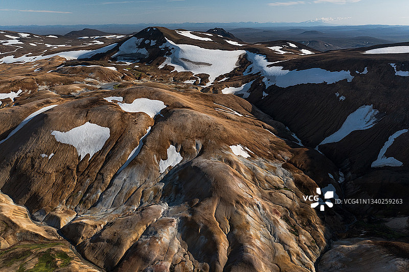 在冰岛冰岛高地的Hveradalir地热区，无人机拍摄的山上融化的雪图片素材