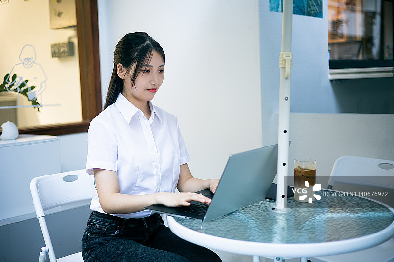 年轻的女商人在咖啡馆用笔记本电脑工作图片素材