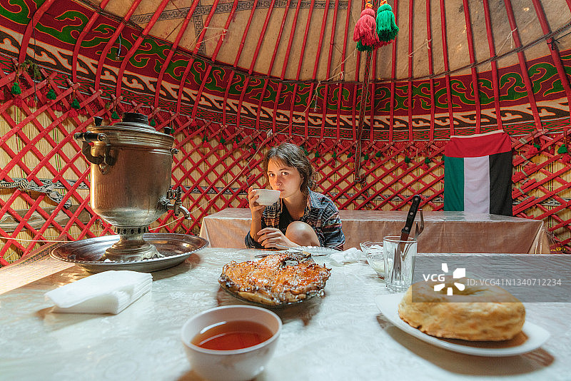 女人在蒙古包里用茶炊喝茶图片素材