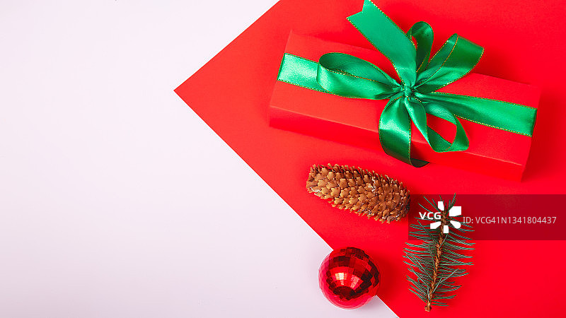 节日组成。礼品盒和圣诞节装饰在红色和白色的背景，平坦的lay，顶部视图复制空间。图片素材