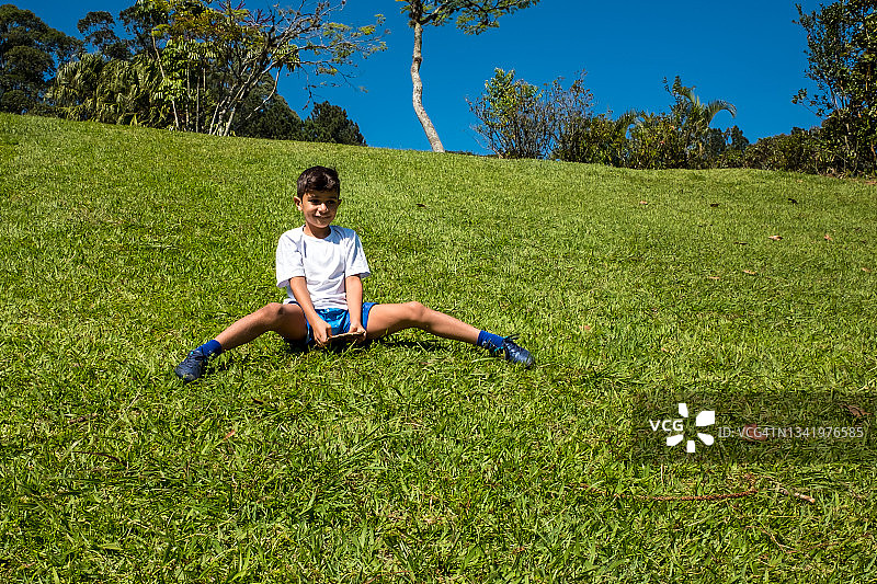 男孩在草地上滑行，玩得很开心图片素材