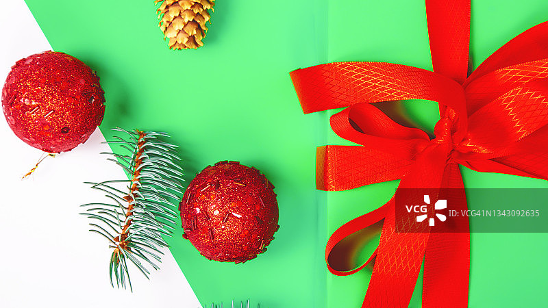 圣诞组成。绿色的礼物，云杉树枝，白色背景上的红色装饰。圣诞节、冬天、新年概念。平躺图片素材