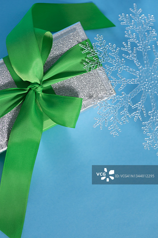 圣诞银质礼品盒和圣诞装饰雪花形状的蓝色背景图片素材
