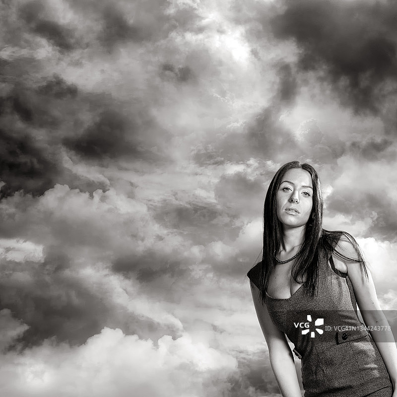 美丽的年轻女子肖像在黑暗的风暴云图片素材