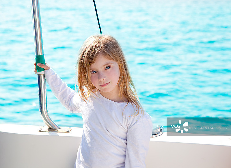 金发小女孩微笑着在船上航行图片素材