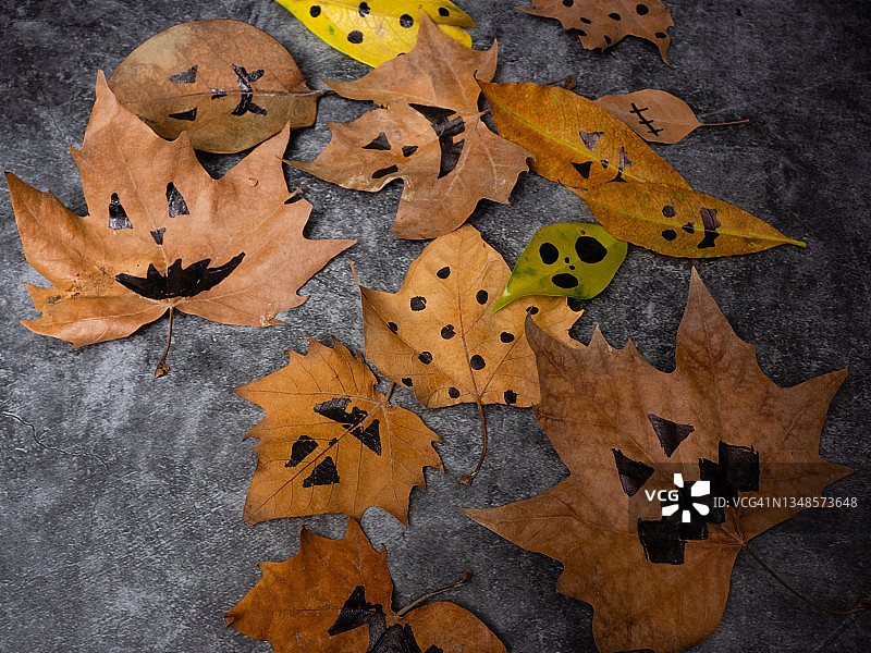 枫叶与彩绘脸装饰为秋季万圣节节日庆祝。10月的万圣节派对。图片素材