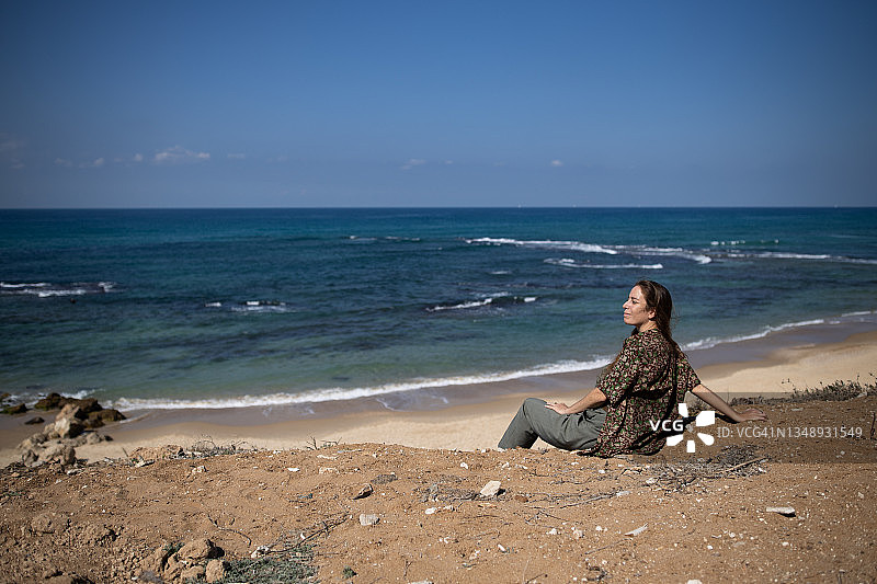 女人坐在沙滩上看风景图片素材