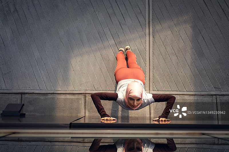 伊斯兰教女运动员扶着墙伸展身体图片素材