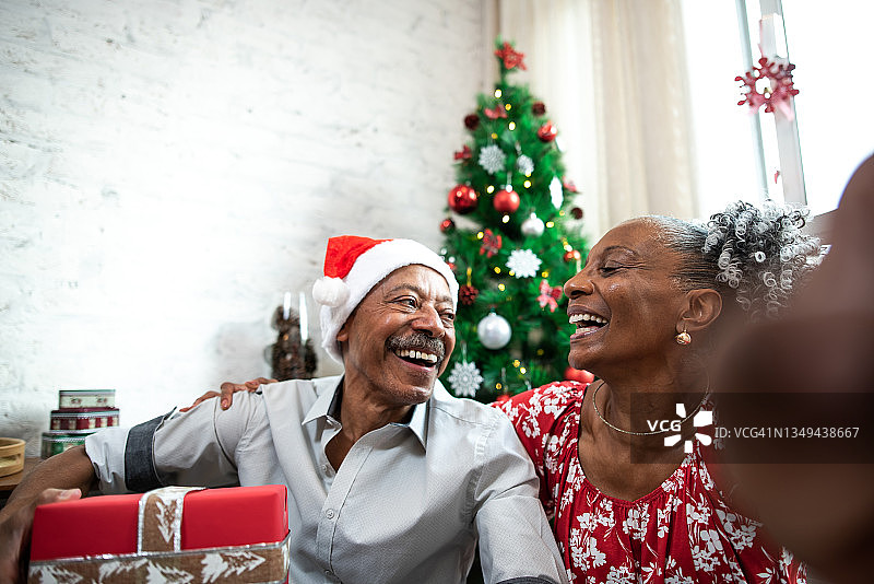 快乐的老夫妇在圣诞节在家。图片素材