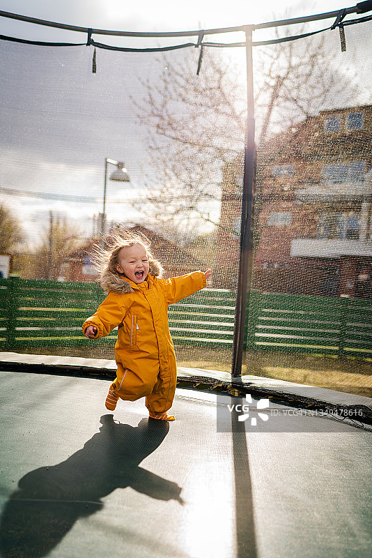 一个孩子在户外享受蹦床图片素材