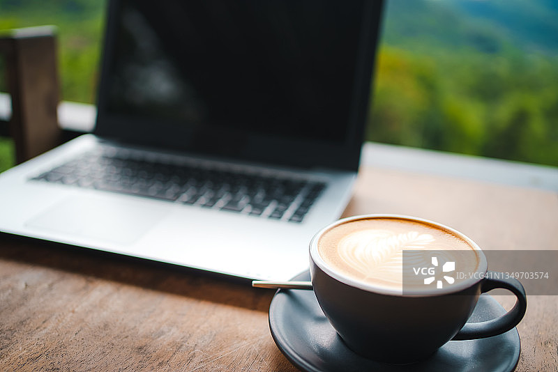 空白的空间，白色的书桌与笔记本电脑屏幕和咖啡杯在自然模糊的背景。图片素材