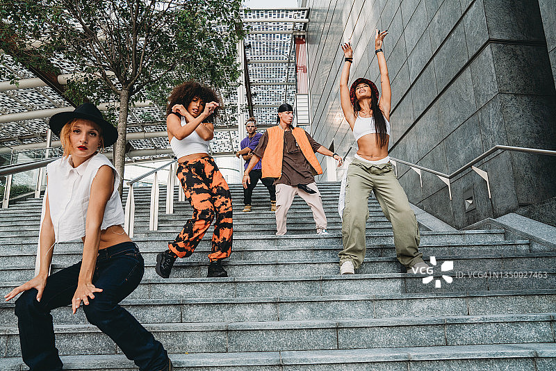 年轻的成年人在城市的现代楼梯上跳舞图片素材