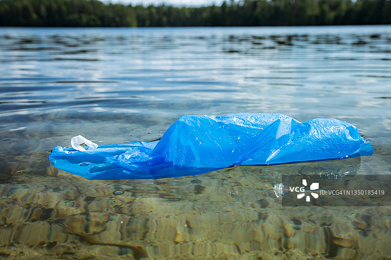用过的塑料袋漂浮在清澈的水中。图片素材
