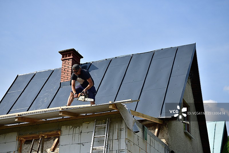 屋顶上的木匠在建筑工地上做木屋顶图片素材