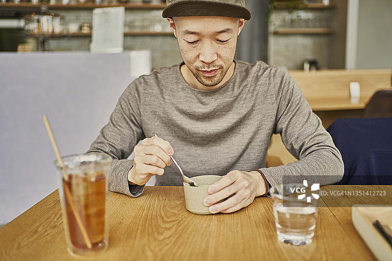 一名亚洲男子在素食咖啡馆享用午餐。图片素材