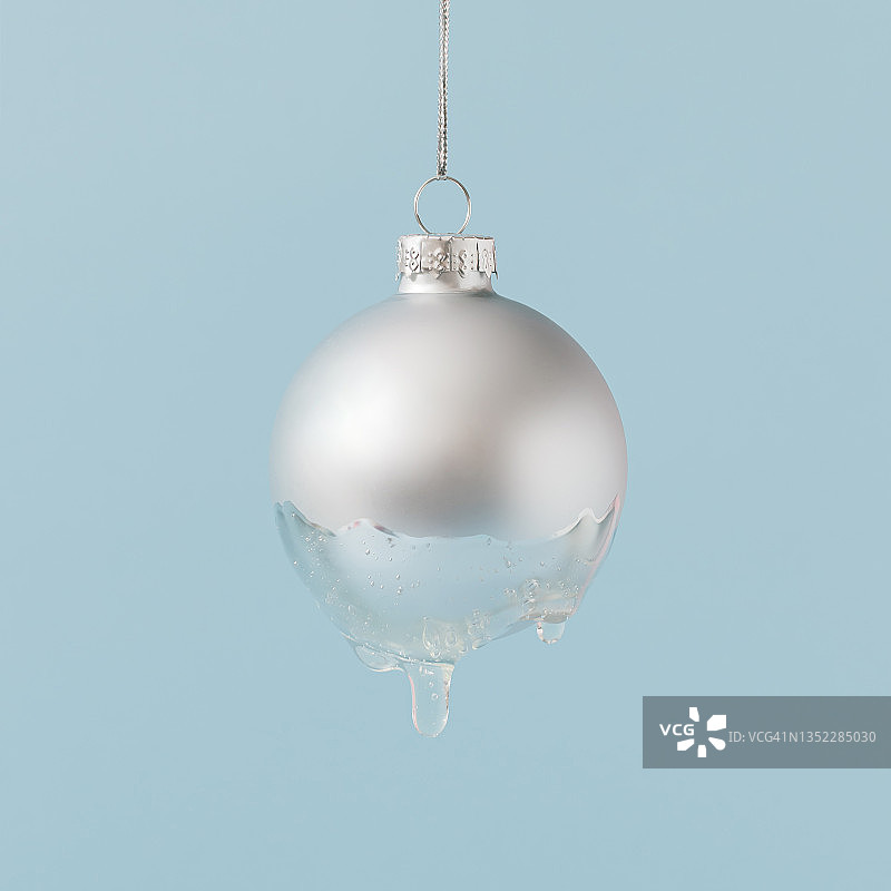 冰冻的银色圣诞小玩意与黏液蓝色背景。最小的新年概念。创造性的冬天的想法。图片素材