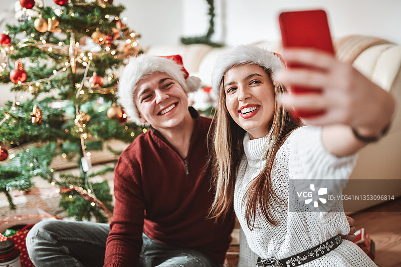 一对微笑的情侣一起庆祝圣诞节的可爱自拍图片素材