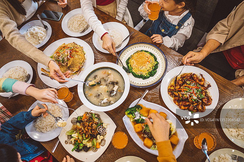 一个亚洲华人家庭在除夕的团圆饭上享用他们自己做的食物图片素材