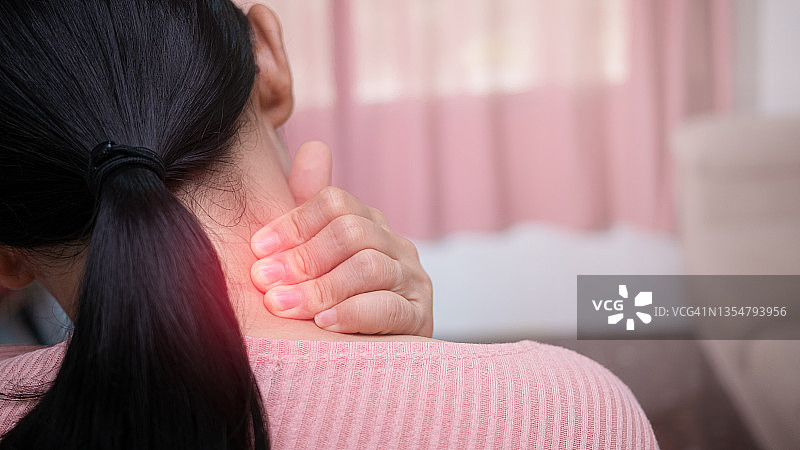 近距离的女性按摩她的疼痛脖子造成的长时间工作在电脑或电话。颈部、梯形和肩部疼痛。肌肉痉挛。图片素材
