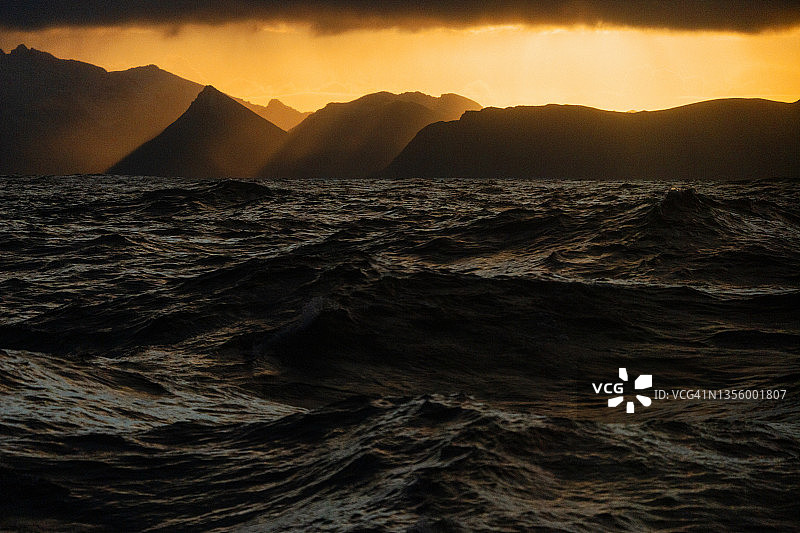 观看汹涌的大海，海浪和罗浮敦群岛的背景图片素材