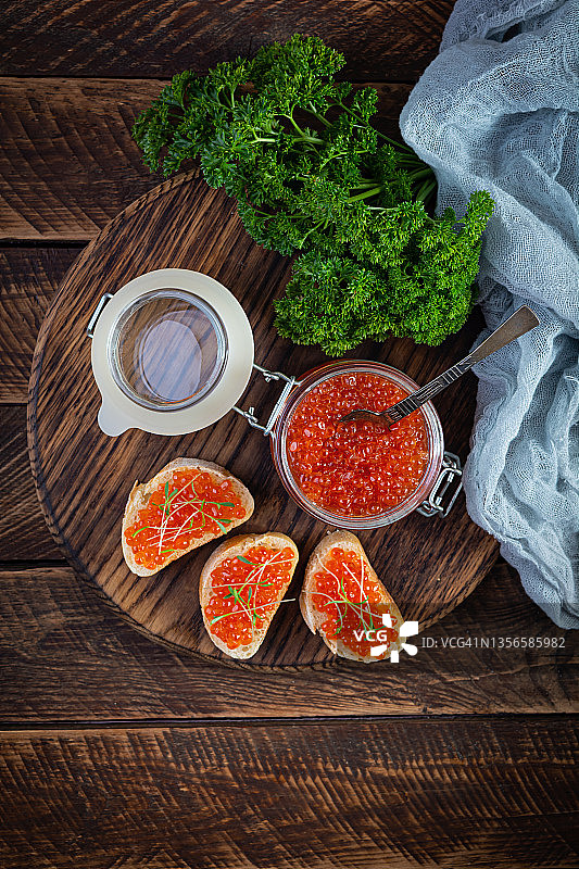 美味新鲜的红色鱼子酱与法式吐司在木制的背景。俯视图图片素材