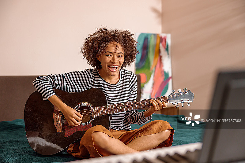 开朗的多种族妇女在家里弹吉他图片素材