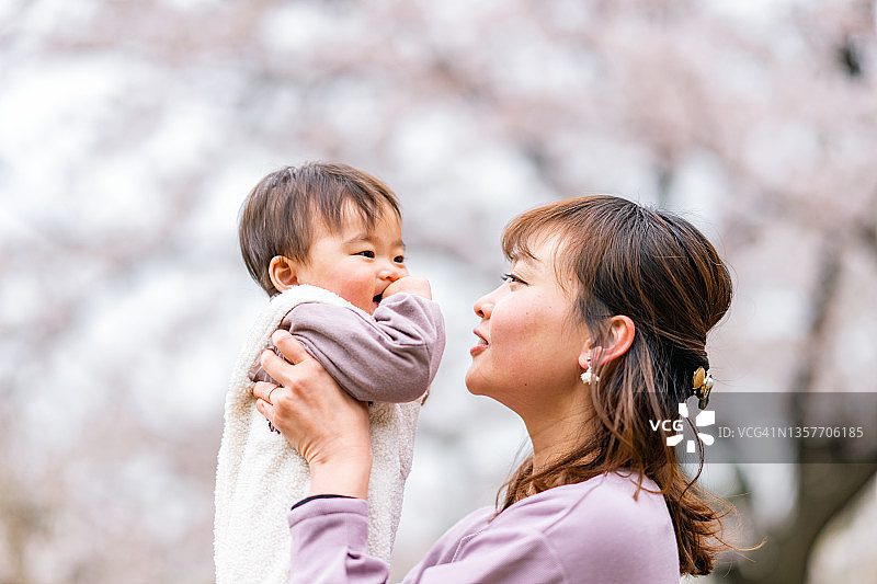 母亲和她的小女儿享受着春天樱花盛开的季节图片素材