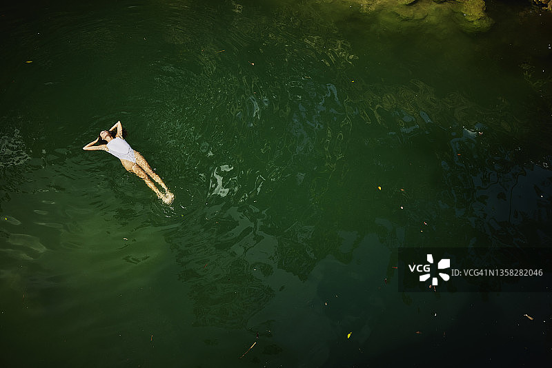 极端广角拍摄的俯视图的妇女漂浮在她的背上在天然井图片素材