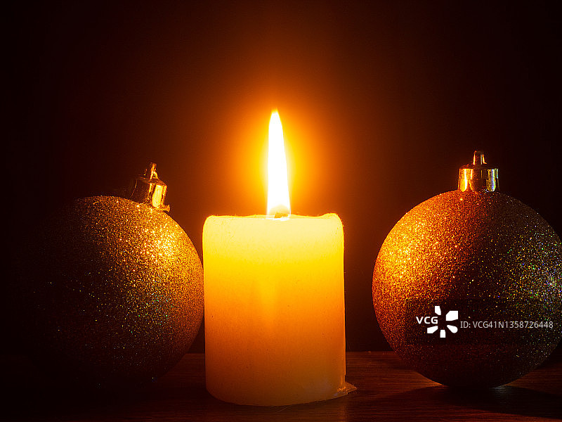 圣诞节时点燃降临节蜡烛和圣诞球。图片素材