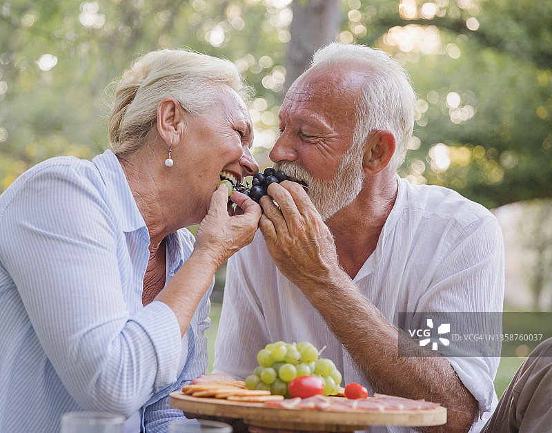 快乐的老夫妇分享葡萄图片素材