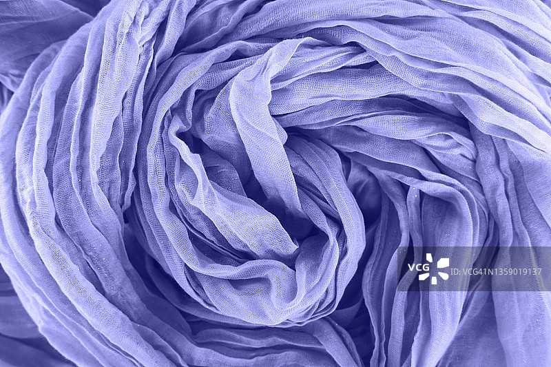 质地轻薄的紫色围巾，折叠成漩涡状。平坦的风格,特写。展示了2022年的颜色。图片素材