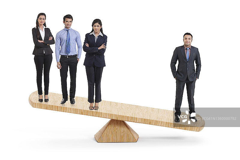 一个不平衡的跷跷板，穿着正装的公司员工站在两端。图片素材