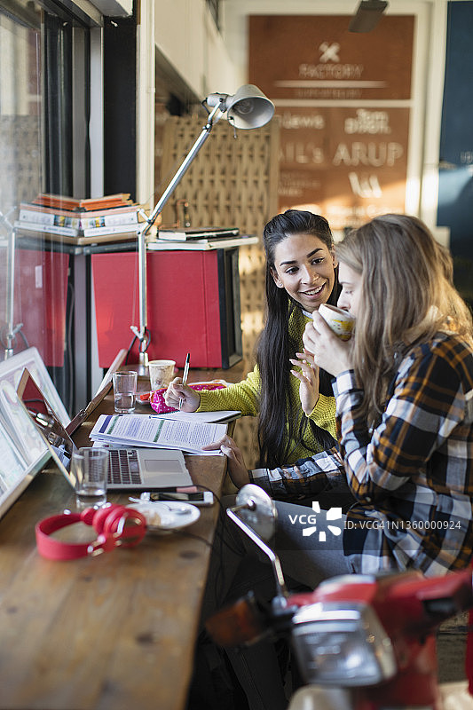 年轻的女大学生在咖啡馆里学习图片素材