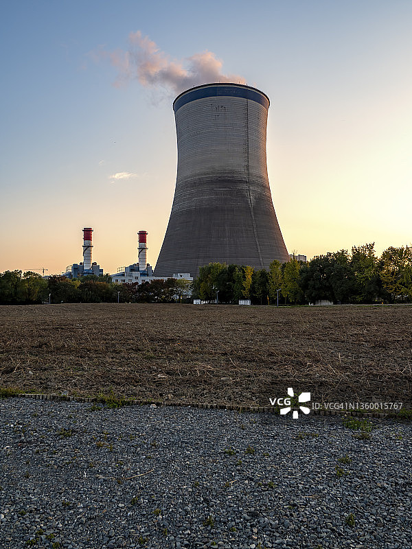 一座热电厂的冷却塔在夕阳中冒着蒸汽图片素材