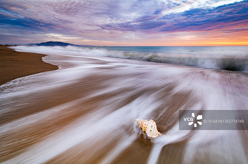 梦幻般的日出和沙滩上的贝壳图片素材