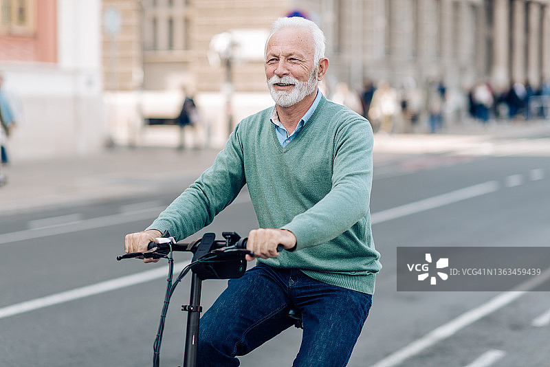 一名商人骑着他的电动自行车上下班的肖像图片素材
