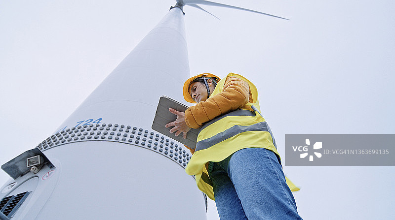 在风电场工作的女性风能工程师。可再生能源系统。碳中和和可持续能源。图片素材