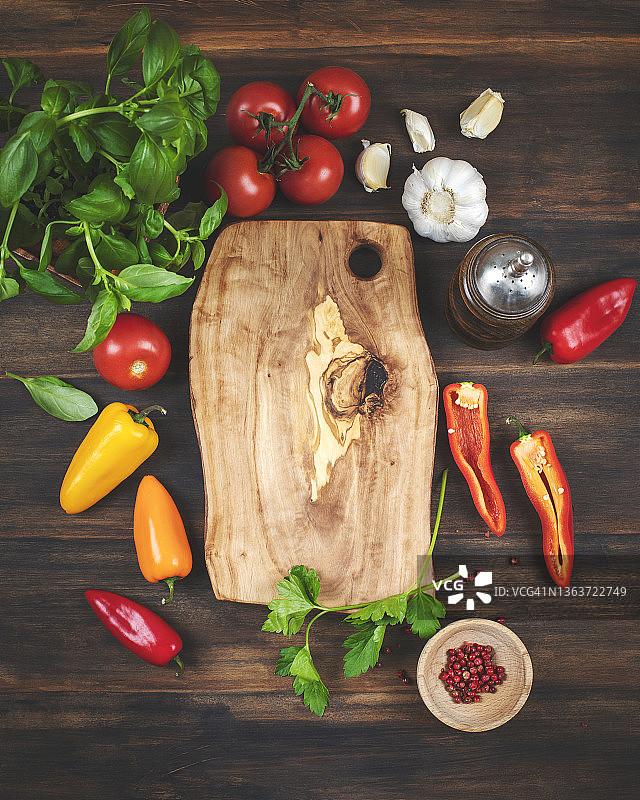 切菜板周围有新鲜蔬菜。为美味的素食烹饪的蔬菜配料。图片素材