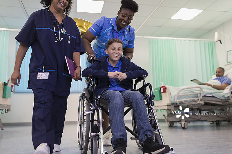 医生和护士在病房用轮椅推着小病人图片素材