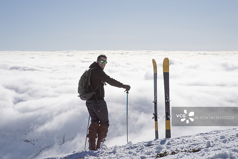 一个年轻人站在云海之上的山顶上图片素材